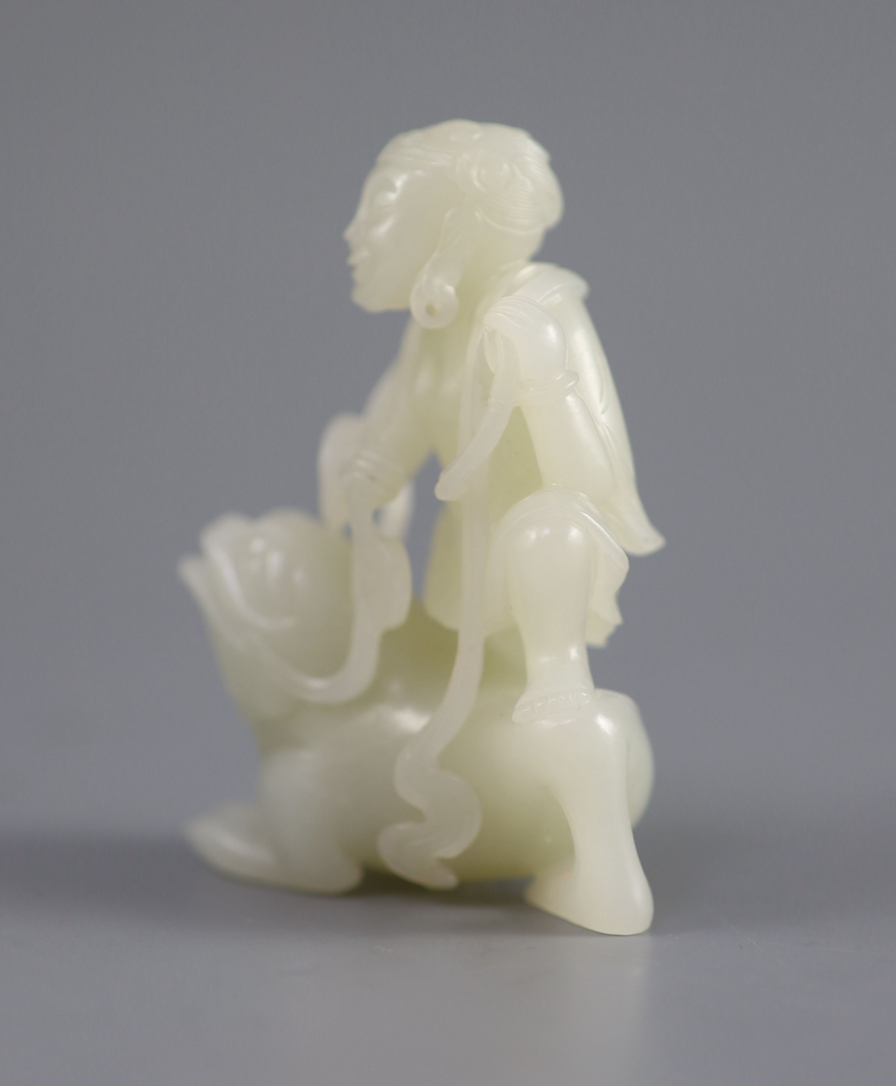 A good Chinese pale celadon jade group of Liu Hai and the three legged toad, 18th century, 8cm high, the wood stand carved with swirling waves